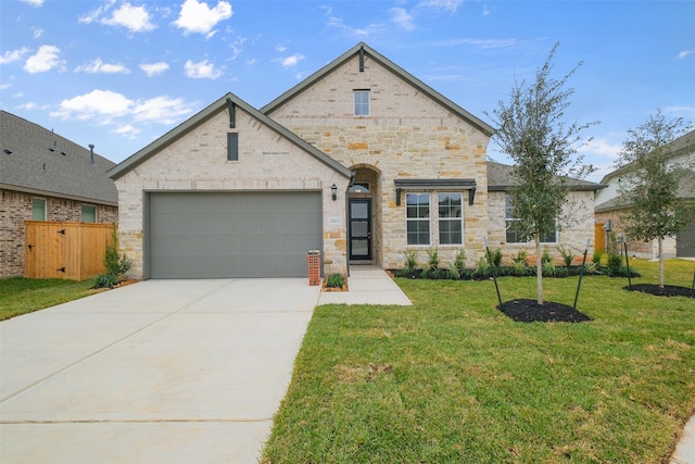 view of front of house with driveway, a front lawn, stone siding, an attached garage, and brick siding