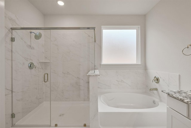 full bathroom featuring a stall shower, vanity, and a garden tub