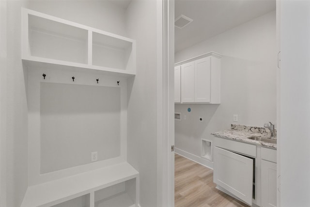 mudroom featuring visible vents, light wood-type flooring, and a sink