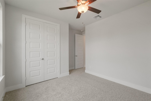 unfurnished bedroom with a ceiling fan, carpet, visible vents, baseboards, and a closet