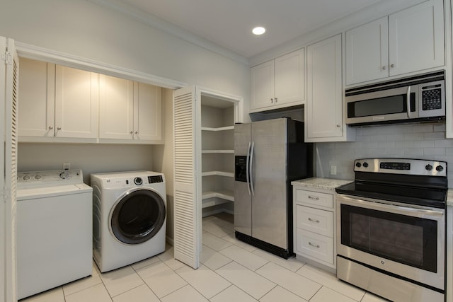 interior space featuring light tile patterned floors, decorative backsplash, independent washer and dryer, and stainless steel appliances