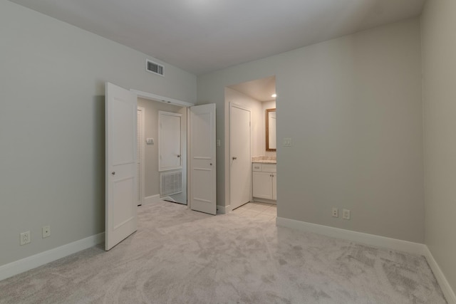 unfurnished bedroom with light carpet, visible vents, and baseboards