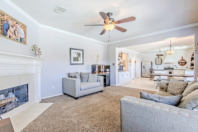 living room with visible vents, light carpet, ornamental molding, a fireplace, and baseboards