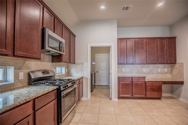 kitchen with visible vents, tasteful backsplash, appliances with stainless steel finishes, light tile patterned flooring, and light stone countertops