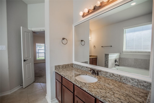 full bath with tile patterned flooring, vanity, and a tub to relax in