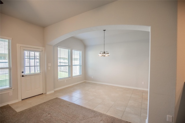 interior space with an inviting chandelier, light tile patterned floors, baseboards, and lofted ceiling