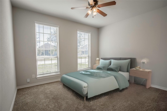 bedroom with a ceiling fan, baseboards, and carpet floors