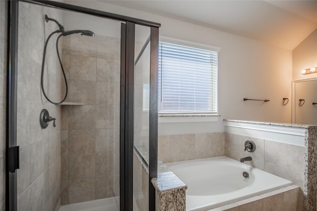 bathroom with a bath, a shower stall, and vaulted ceiling