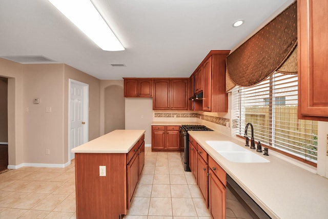 kitchen featuring visible vents, a sink, under cabinet range hood, stainless steel appliances, and light countertops