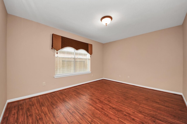 empty room with baseboards and dark wood finished floors