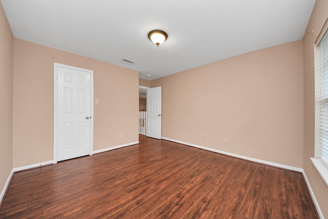 unfurnished bedroom featuring visible vents, baseboards, and wood finished floors