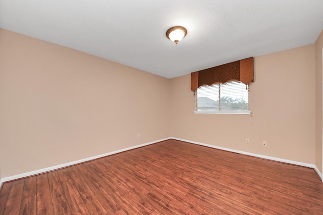 empty room featuring baseboards and wood finished floors