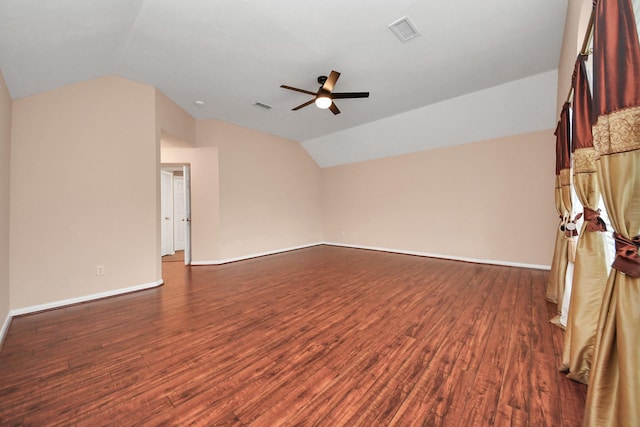 interior space featuring visible vents, dark wood-type flooring, baseboards, vaulted ceiling, and a ceiling fan