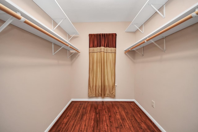 walk in closet with wood finished floors