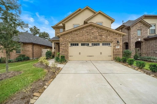 view of front of house with a front yard, driveway, stucco siding, a garage, and brick siding