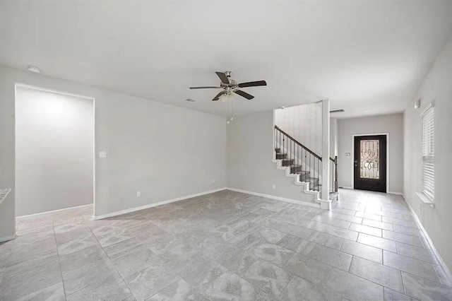 foyer entrance featuring visible vents, baseboards, ceiling fan, and stairs