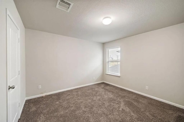 carpeted empty room featuring visible vents, a textured ceiling, and baseboards