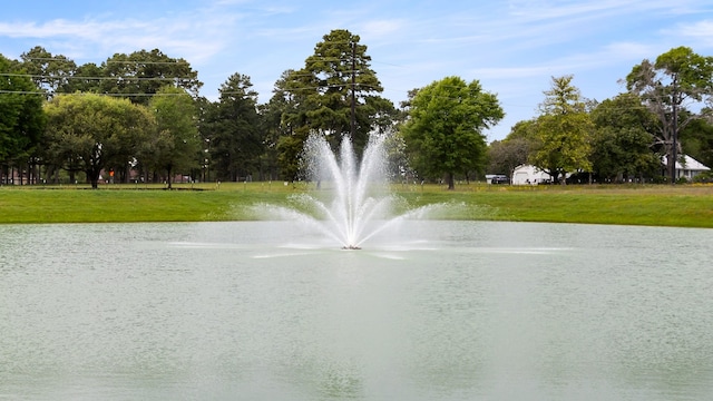 surrounding community featuring a lawn and a water view