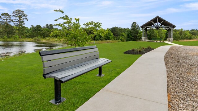 view of community with a gazebo, a lawn, and a water view