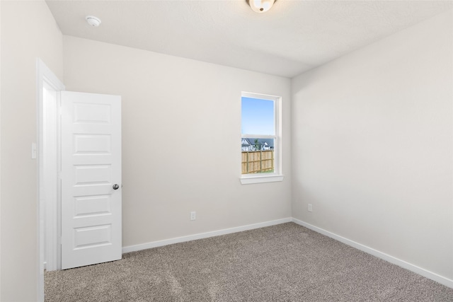 spare room with carpet flooring and baseboards