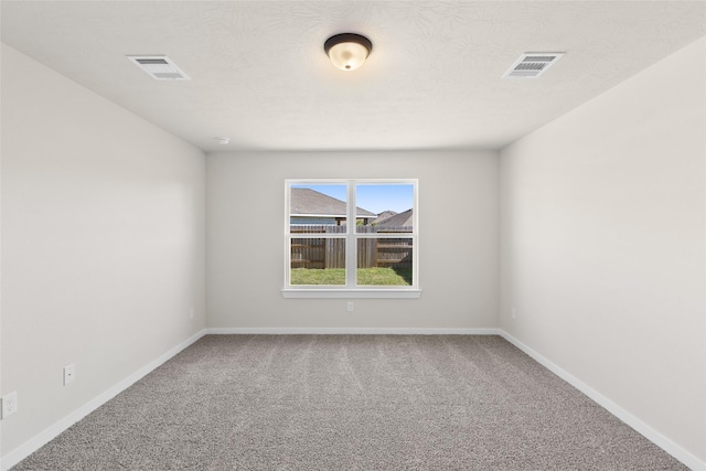 spare room featuring visible vents, baseboards, and carpet