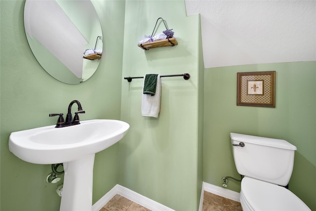 bathroom featuring baseboards and toilet