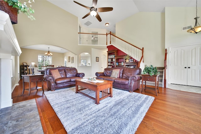 living room with visible vents, arched walkways, and wood finished floors