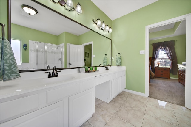 ensuite bathroom with a stall shower, a sink, ensuite bath, tile patterned flooring, and double vanity