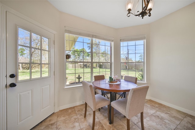 dining area featuring baseboards and a chandelier