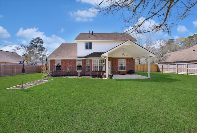 rear view of property with brick siding, ceiling fan, a lawn, a fenced backyard, and a patio area