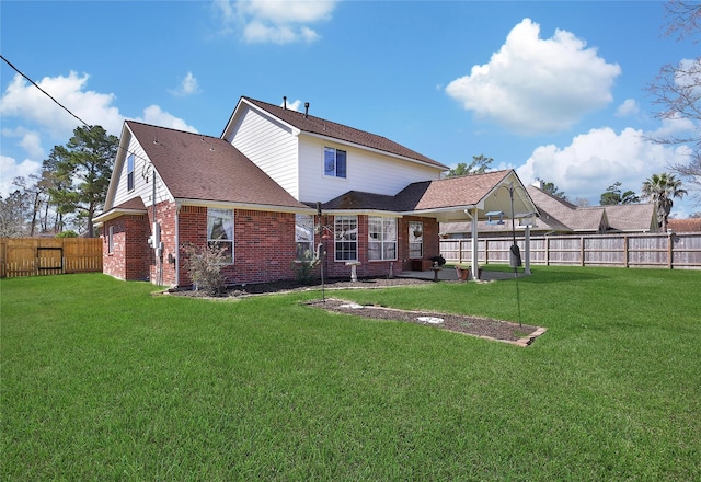 back of property with brick siding, a fenced backyard, a shingled roof, and a yard