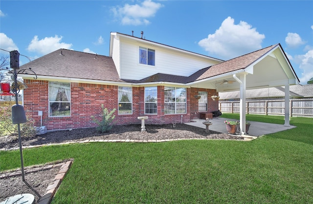 back of property featuring a patio area, fence, brick siding, and a lawn