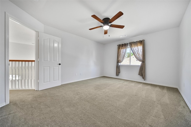 empty room featuring visible vents, carpet floors, baseboards, and ceiling fan