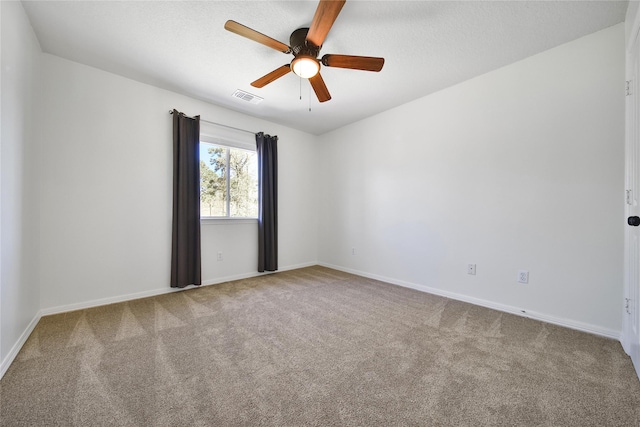 carpeted empty room featuring visible vents, a textured ceiling, baseboards, and ceiling fan