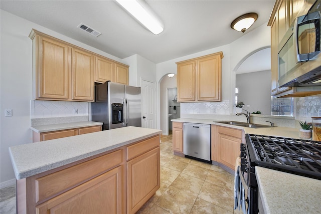 kitchen featuring visible vents, light brown cabinets, stainless steel appliances, and a sink