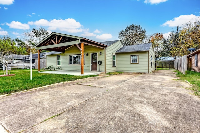 view of front of home with driveway, a patio, a trampoline, fence, and a front yard