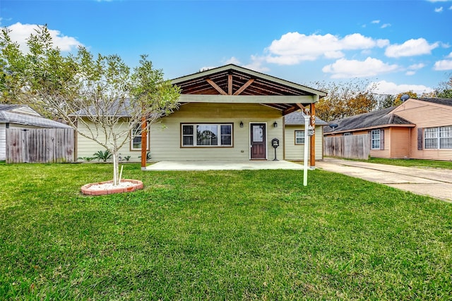 view of front of house with driveway, a front yard, and fence