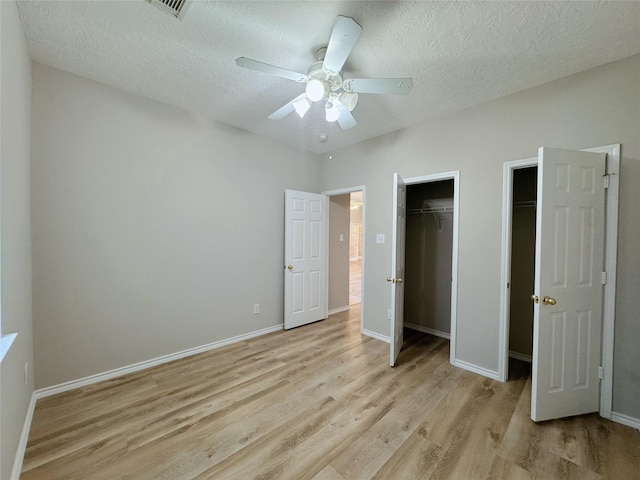 unfurnished bedroom with light wood-style flooring, baseboards, and a textured ceiling