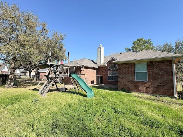 view of playground with cooling unit, fence, and a lawn