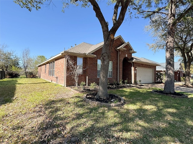 view of side of property featuring brick siding, an attached garage, a yard, and fence