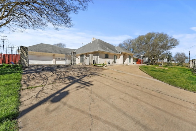 view of front facade with a front yard, fence, and driveway