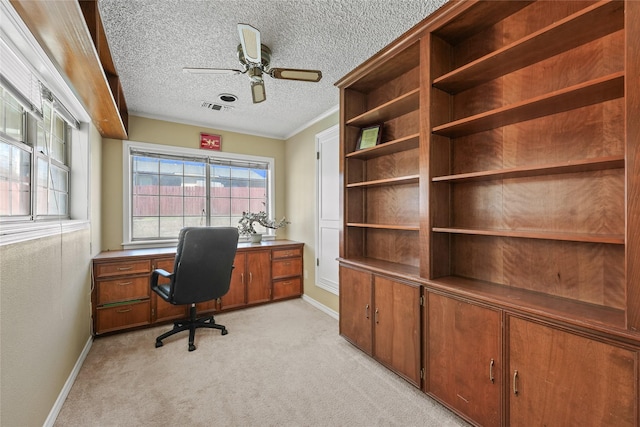 office space with a ceiling fan, baseboards, visible vents, a textured ceiling, and light colored carpet