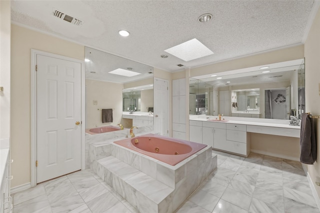 full bath with visible vents, marble finish floor, a textured ceiling, a skylight, and a whirlpool tub