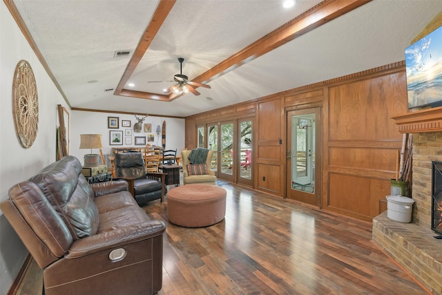 living room with visible vents, crown molding, hardwood / wood-style floors, a fireplace, and a textured ceiling