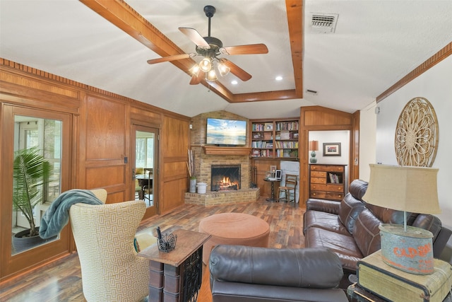 living area with visible vents, wood walls, lofted ceiling with beams, and wood finished floors