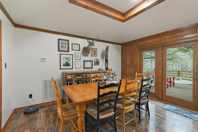 dining area featuring hardwood / wood-style floors, crown molding, baseboards, and visible vents