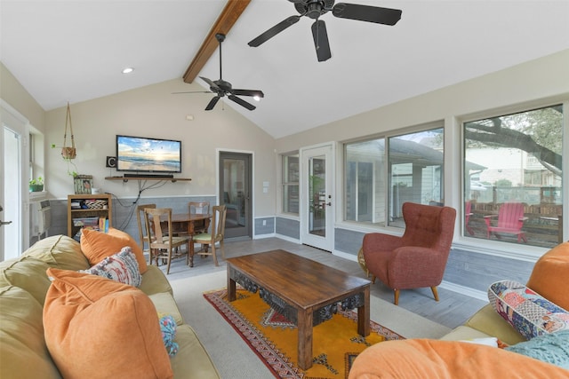 living area featuring a wealth of natural light, baseboards, beam ceiling, and wood finished floors