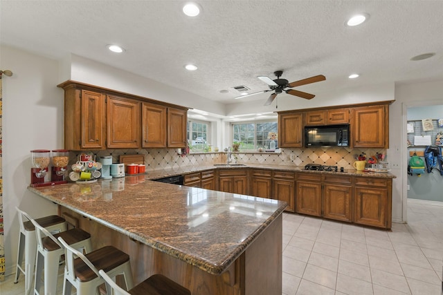 kitchen featuring a sink, brown cabinets, and black appliances