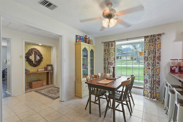 dining space with a wealth of natural light, visible vents, a textured ceiling, and light tile patterned floors