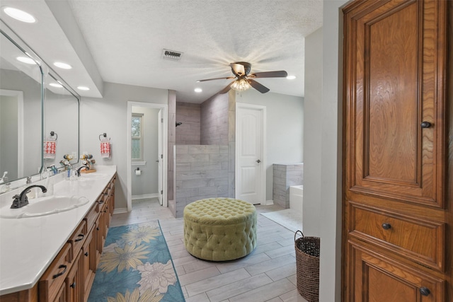 bathroom featuring a bath, a walk in shower, visible vents, and a sink